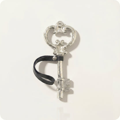 Adorno de llave antigua con correa de cuero plateada